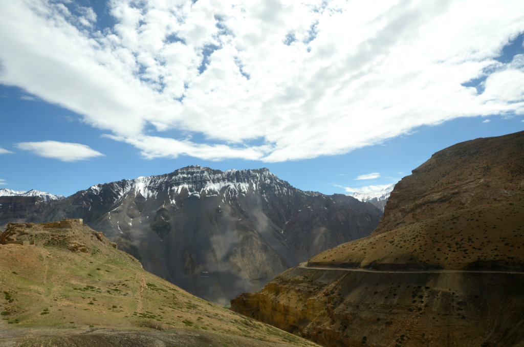 Scenes from Kinnar and Spiti road trip. Blue sky, white clouds and winding roads in the mountains.