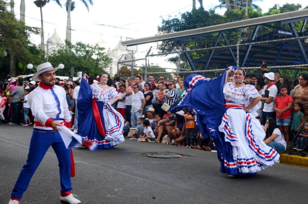 Group of men and women performing in traditional costumes. Heredia parade, Costa Rica independence day celebration.