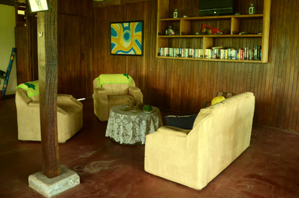 Seating area and reading corner, couches and bookshelf, at Casa Sarapiqui