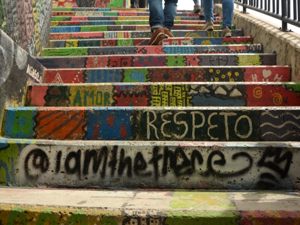 Comuna 13 graffiti - Stair case with wall art displaying very strong positive traits, like love and respect.