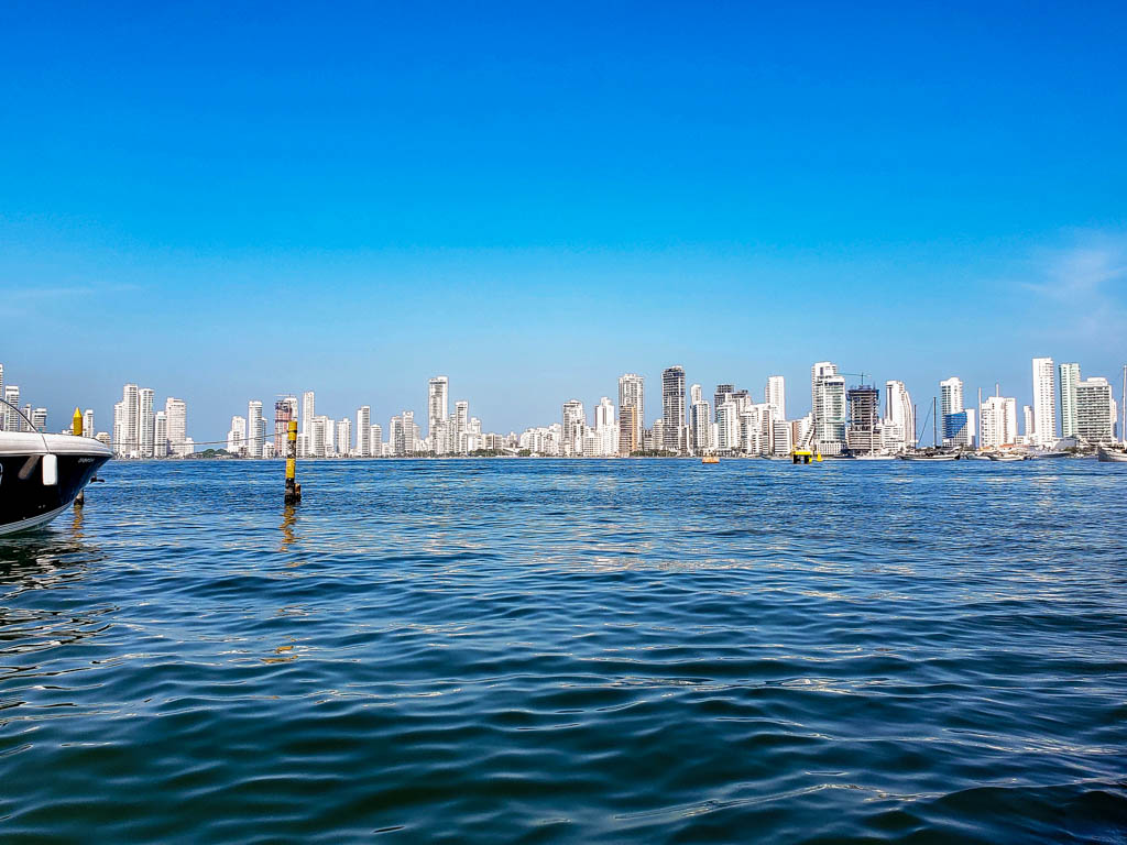 La Bodeguita dock - Blue Caribbean Sea with Cartagena's skyline of white tall buildings in the background.