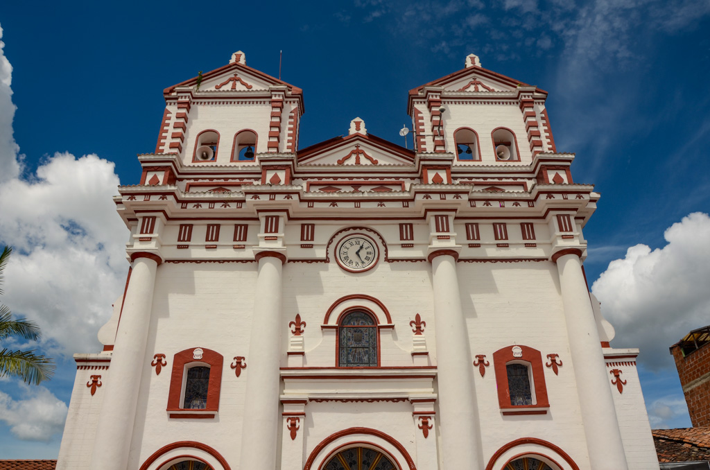 White colored church building against the background of blue sky. Guatape church.
