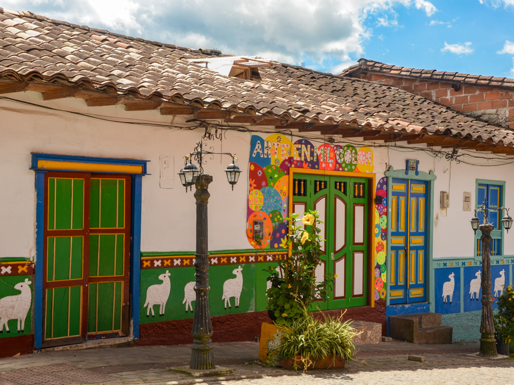 Guatape houses with green and blue zocalos, colorful doors and windows.