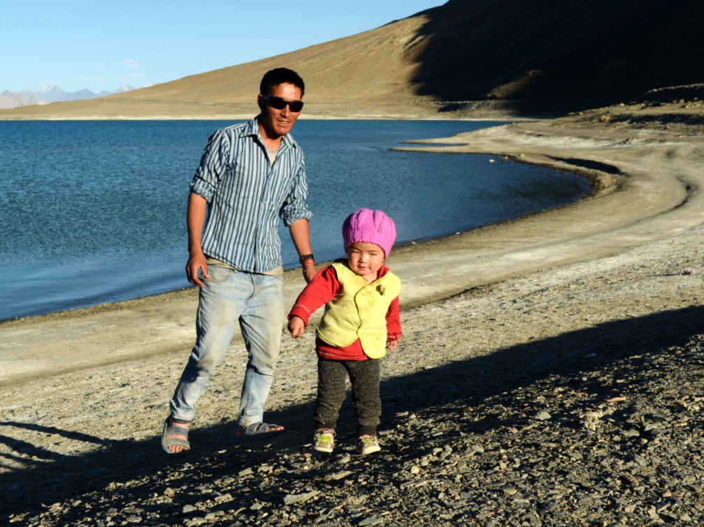 A man with his baby boy, by the pristine blue Pangong lake