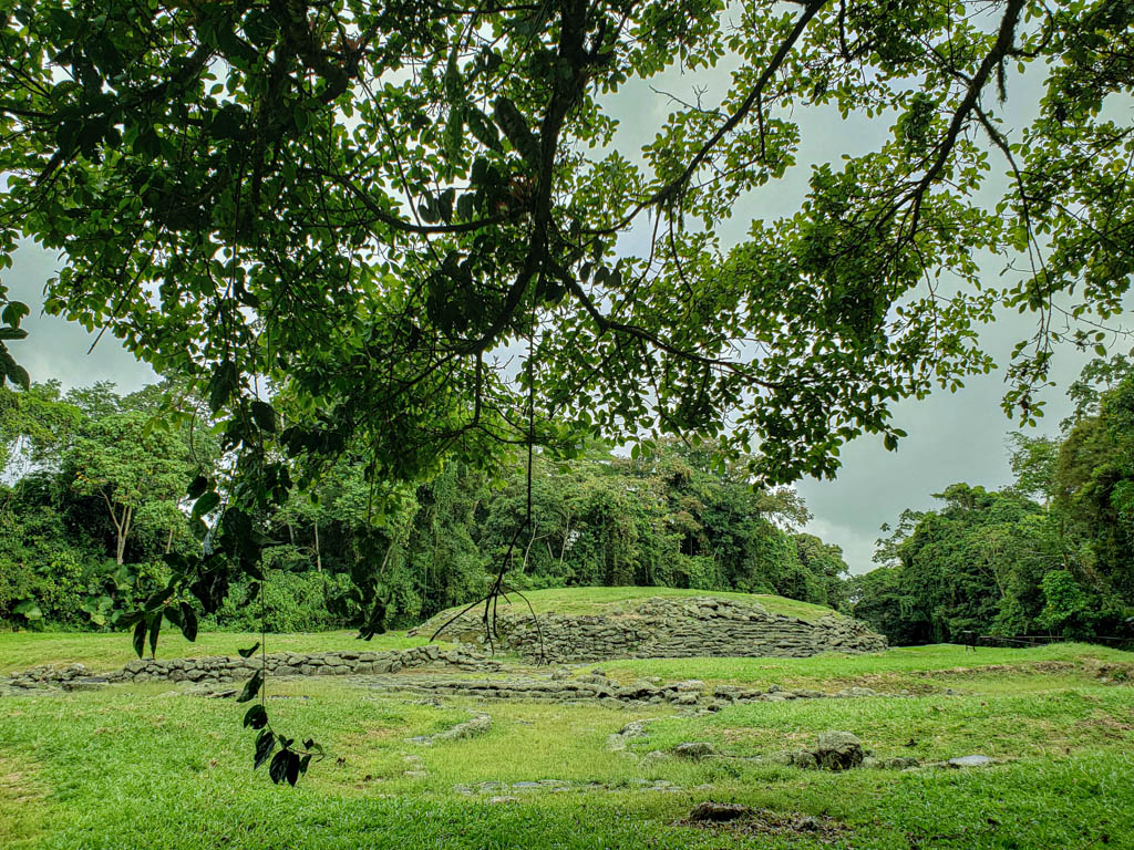 Central mound, an elevated circular platform with stone platform and green grass top. Guayabo National Monument.