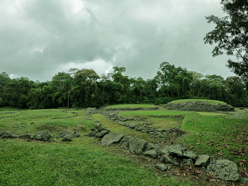 Remnants of Guayabo. The central mound, the green fields and the jungle on an overcast day, at Guayabo National Monument.