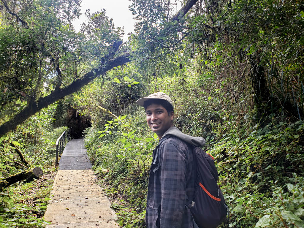 Indranil, smiling at the camera, happy to hike in Los Quetzales National Park.