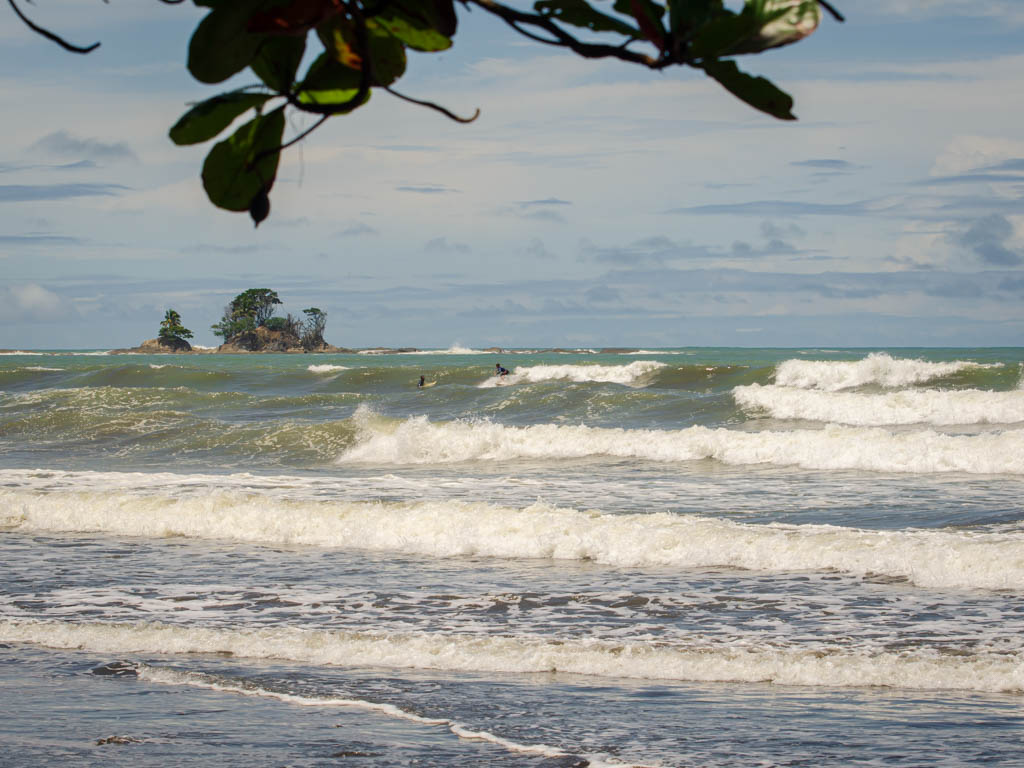 Waves and Surfs. A little island visible in the distant horizon.