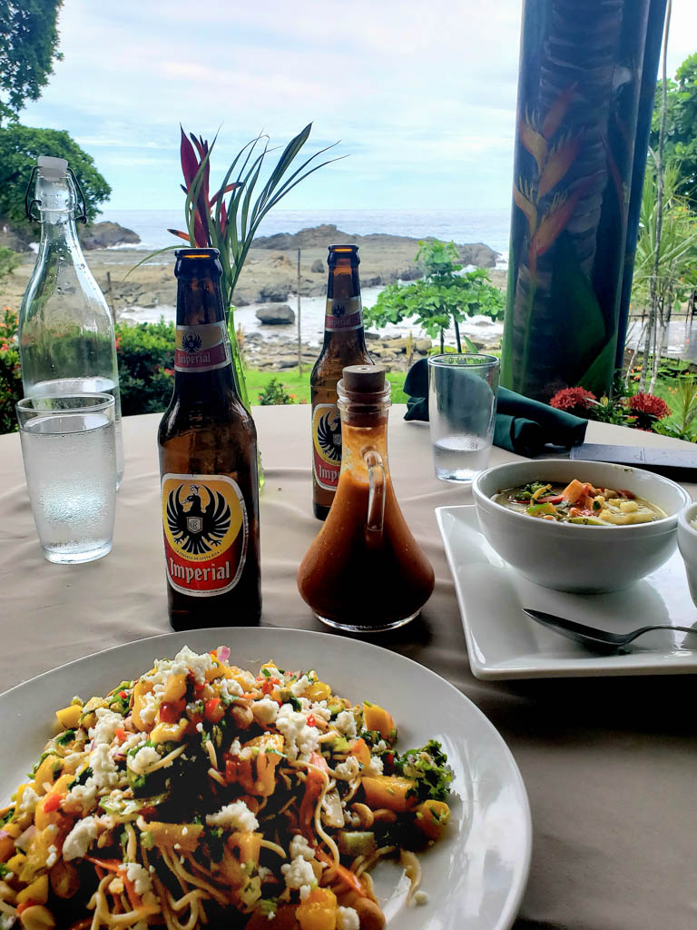 Lunch with a view at ¿Por Que No? Lunch plates and beer bottles laid on the table. Ocean view restaurant.