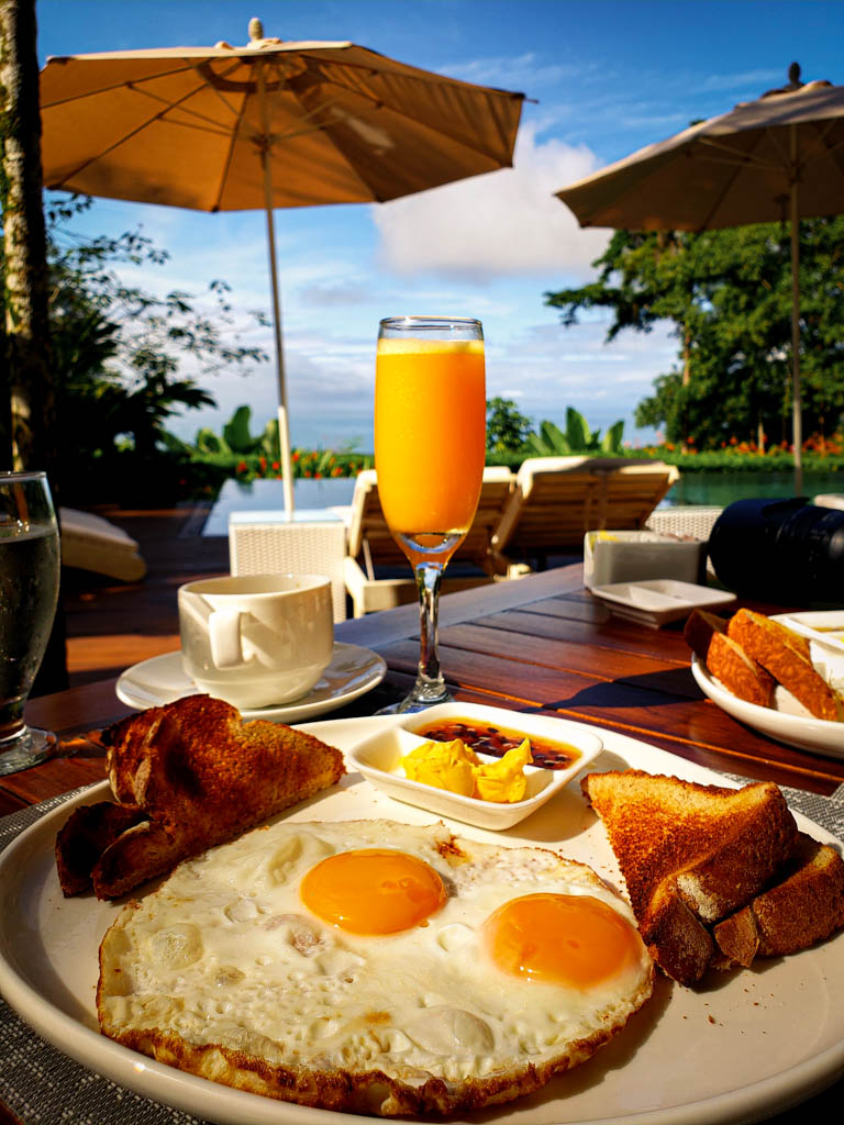 Breakfast of bread, butter, jam, coffee, orange juice, eggs to order by the pool at Oxygen Jungle Villas