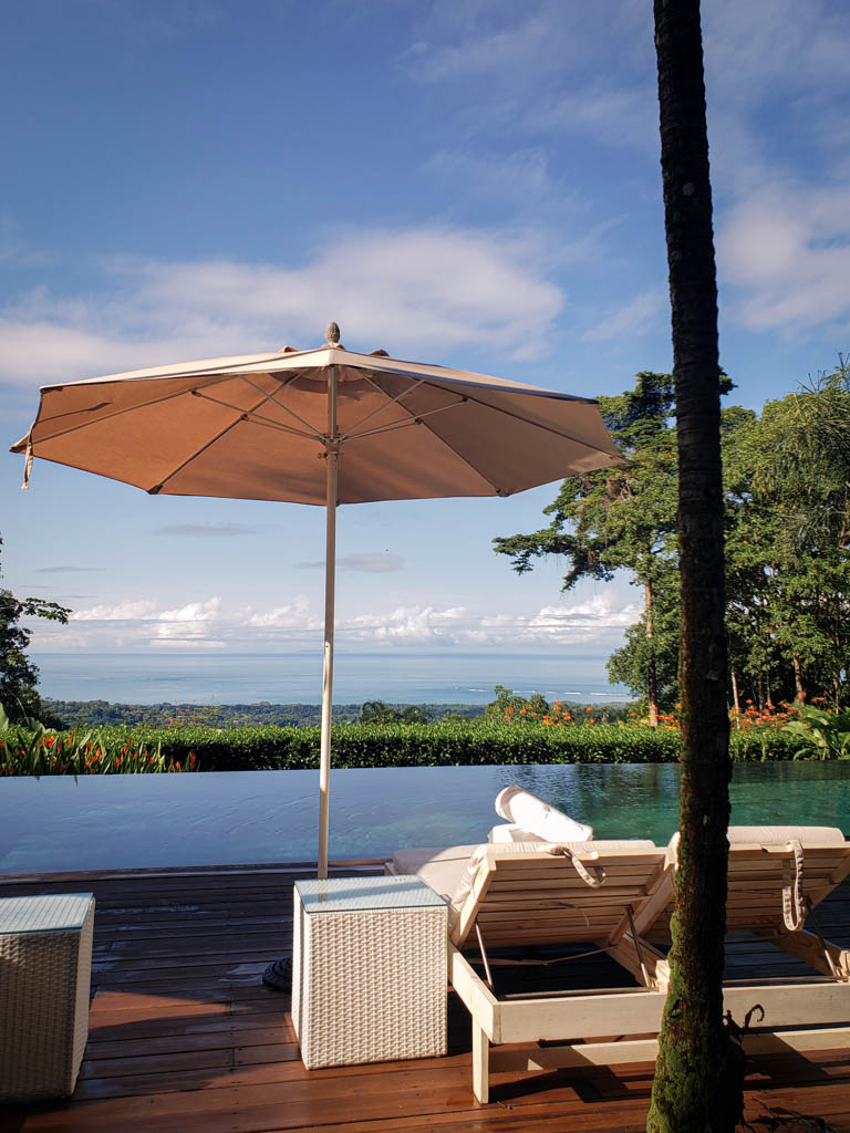 Sunbeds by the infinity pool with a view of Marino Ballena National Park