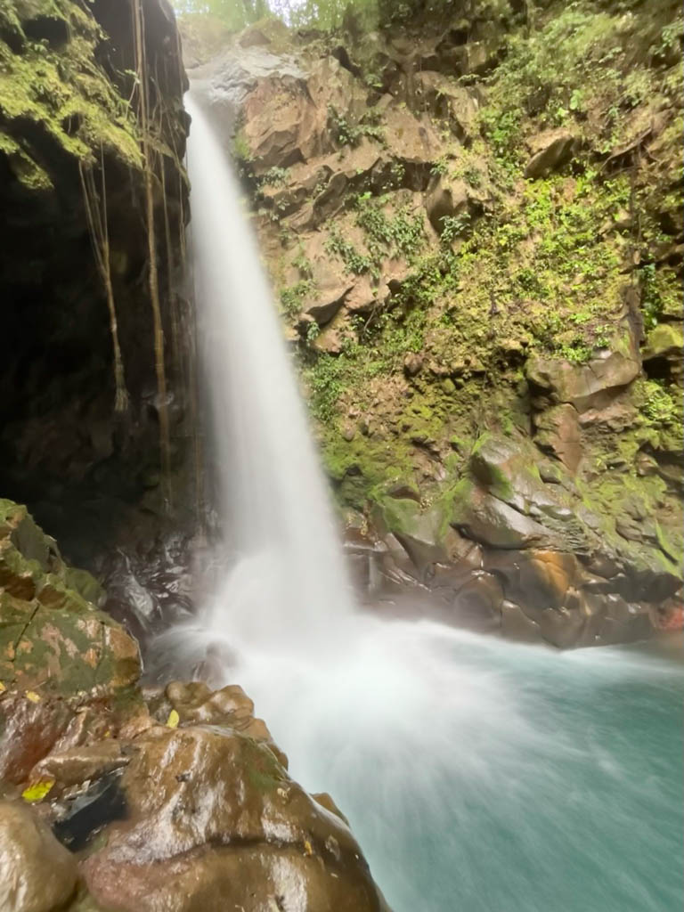 Catarata Oropendola or Oropendola Waterfall splashing into a turquoise pool.