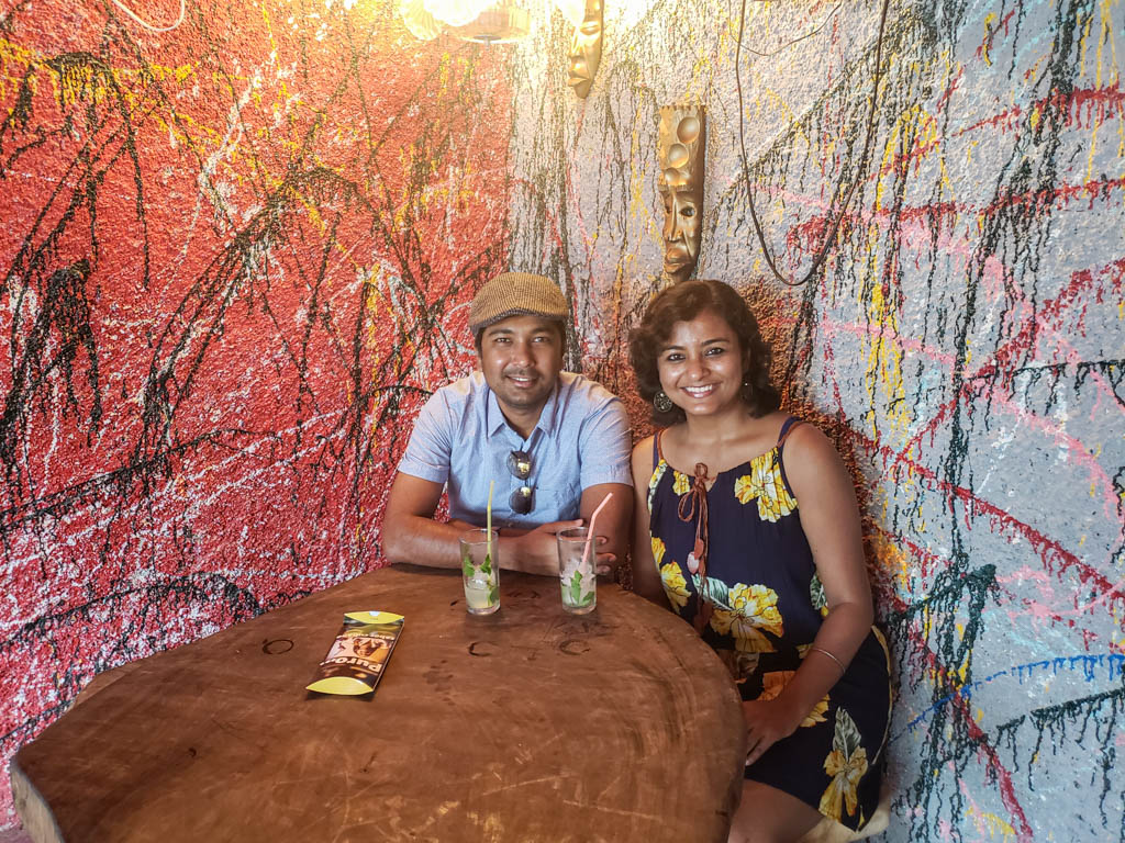 Paradise Catchers, seated in a cafe in Callejon de Hamel. The walls have red and other colorful artwork.