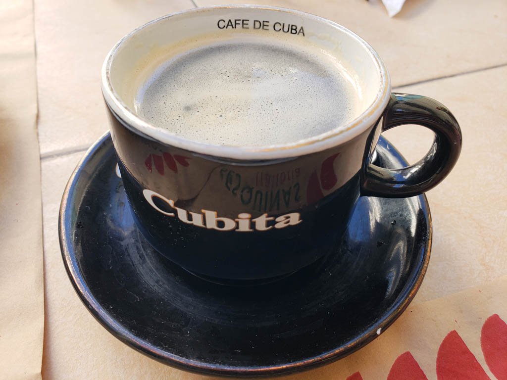 A cup of Cuban coffee in a black cup with white text, saying Cubita.