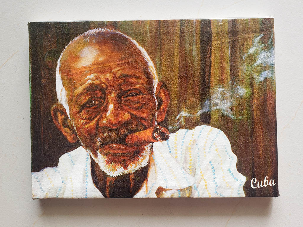 Paintings of an old Cuban man with prominent wrinkles smoking cigar. Paintings are common souvenir in Cuba.