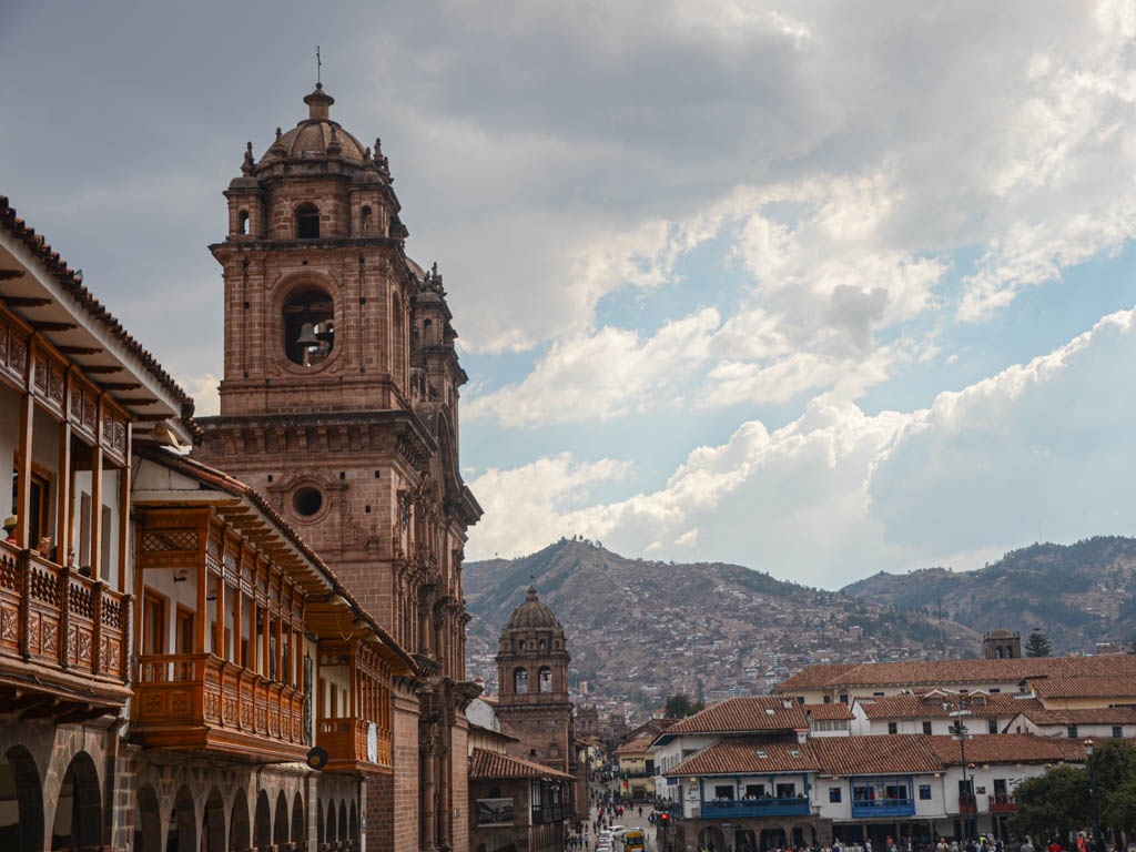 Impressive city views of Cusco - Cusco cathedral in the foreground and the mountain city in the background.