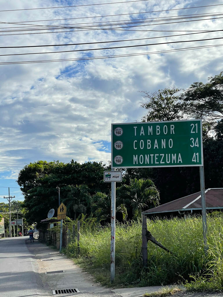 Distance signs of Tambor, Cobano and Montezuma, on a green board, in the town of Paquera.