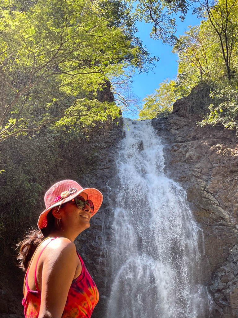 A smiling woman in front of the lower Montezuma Waterfall