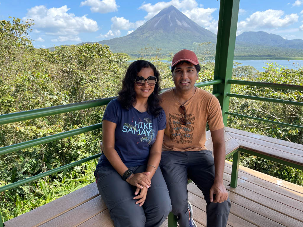 Man and Woman sitting on the watch tower of the Peninsula sector. Arenal Volcano and Arenal Lake are seen in the background.