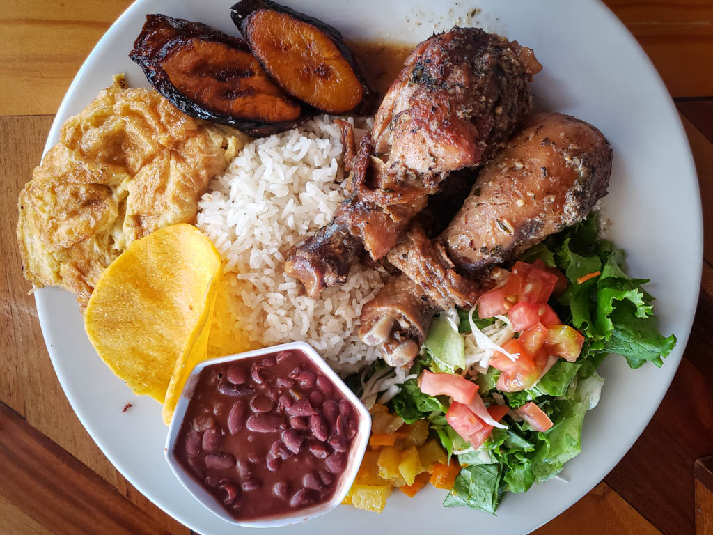 Casado with Caribbean style chicken, served on a white plate, at Sabor Tico restaurant, Monteverde.
