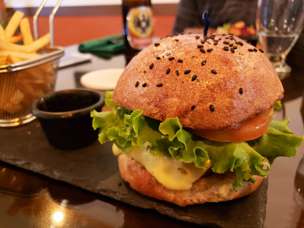 Lamb burger, served on a black plate, at The Green Restaurant, Monteverde.