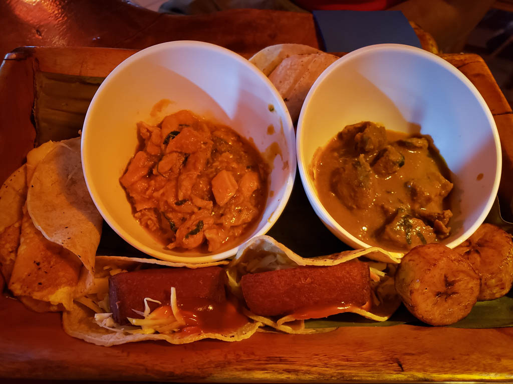 Tablita tipica: Costa Rican meat platter, with one bowl of chicken, one bowl of beef, pork sausages, fried plantains and tortillas on the side.