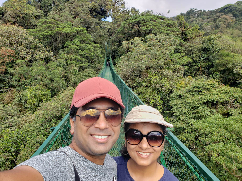A man and woman on a hanging bridge in Selvatura Park.