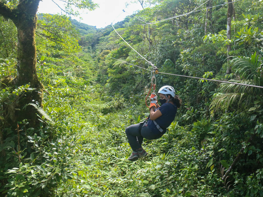 A woman on a canopy tour surrounded by cloud forests.