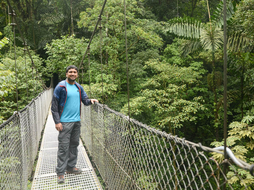 A man, posing on a hanging bridge in the Mistico Arenal Hanging Bridges Park.