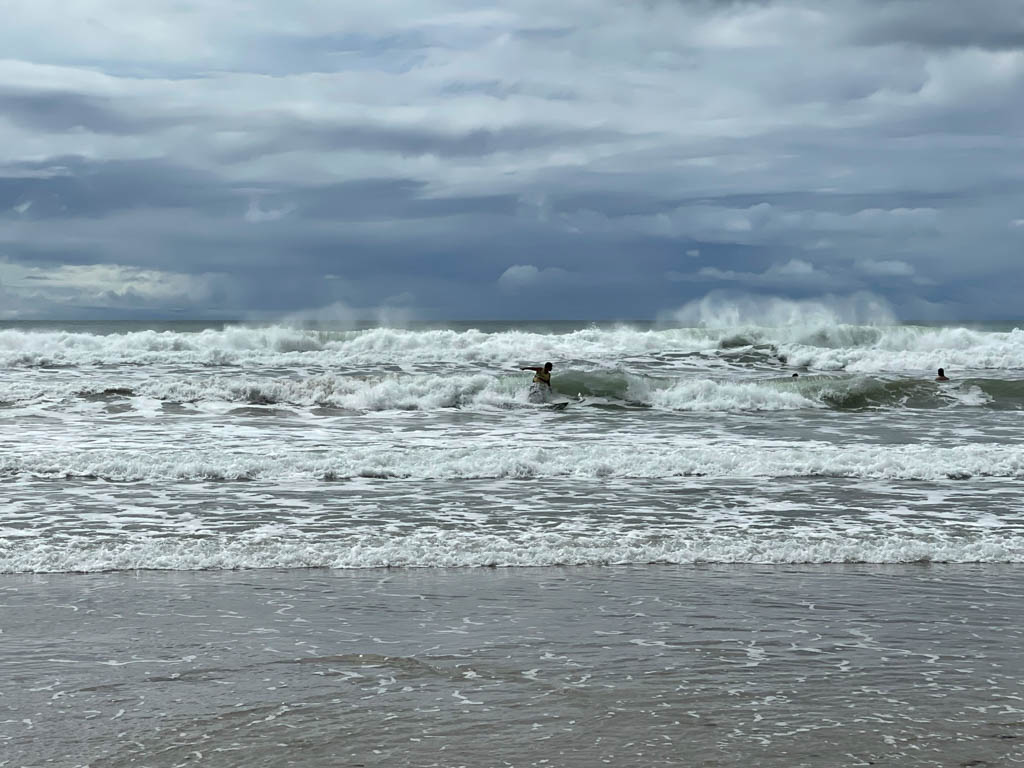 A surfer, surfing the waves at Playa Carmen in Santa Teresa, Costa Rica.