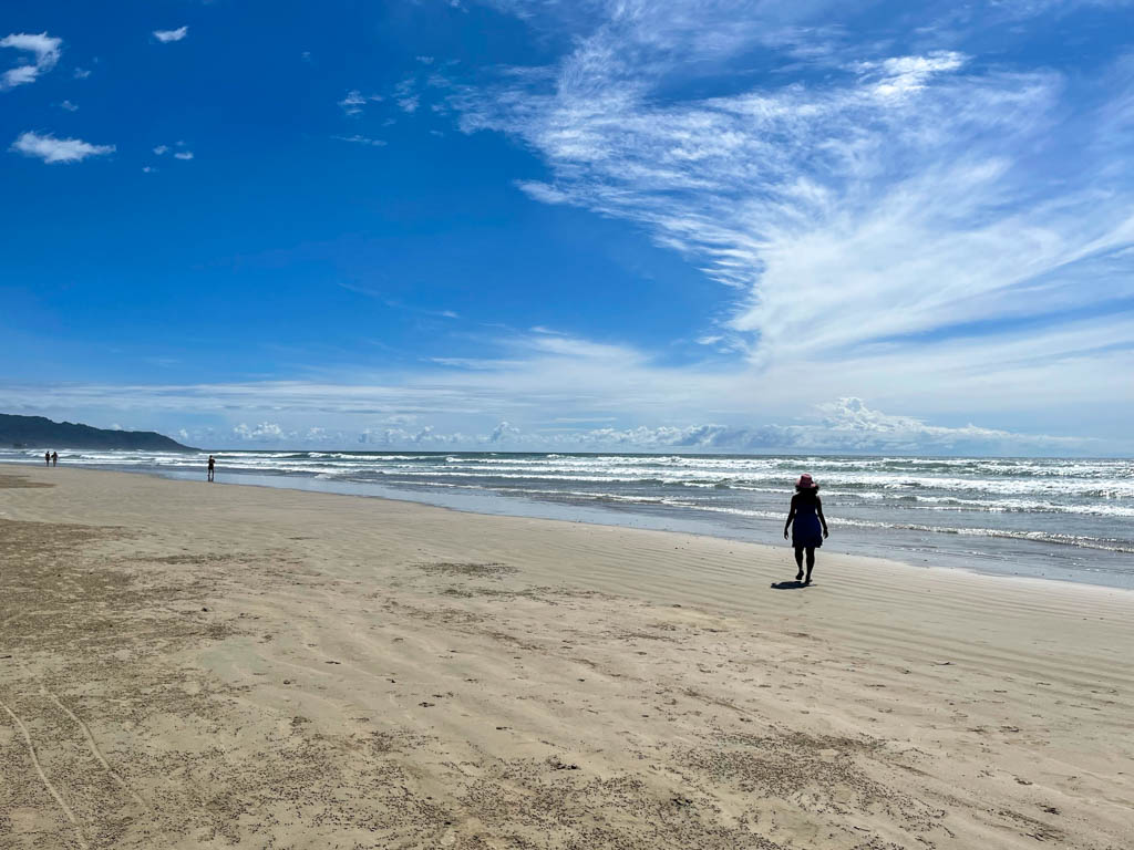 A woman, enjoying her walk on the long stretch of Playa Hermosa in Santa Teresa.