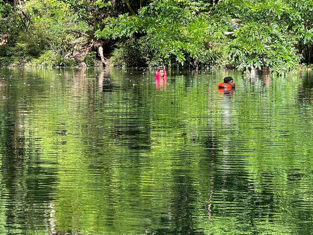 A man and a woman floating in the Rio Claro.