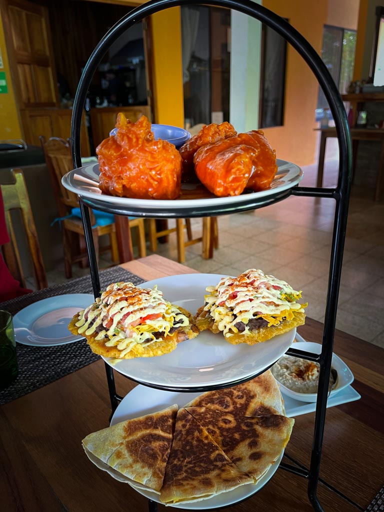 Food rack containing chicken wings, loaded patacones and quesadillas at Los Laureles restaurant in Uvita.