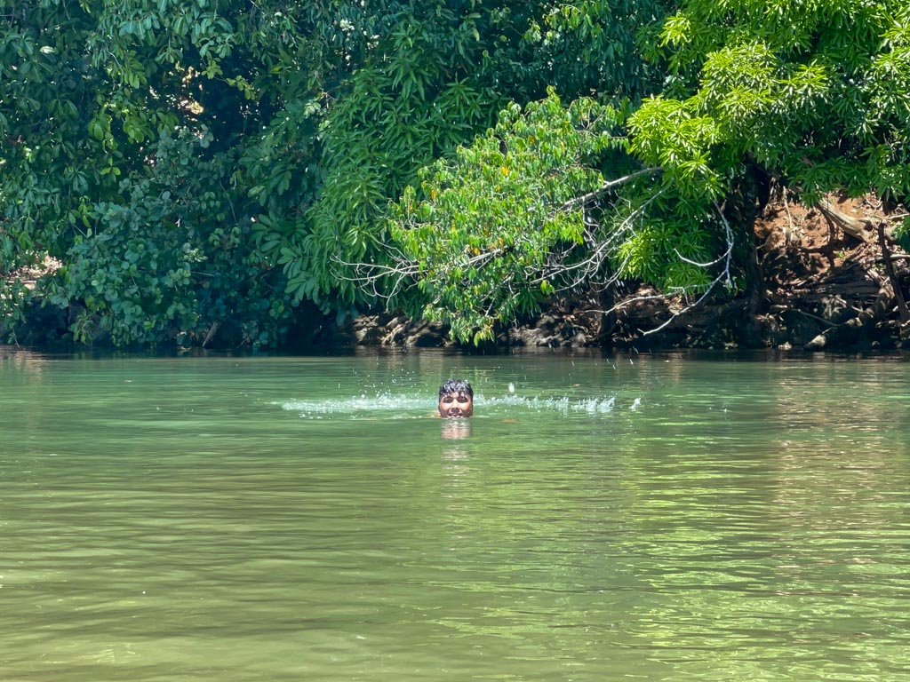 A man enjoying his swim in the river surrounded by rainforest in Drake Bay, Costa Rica.