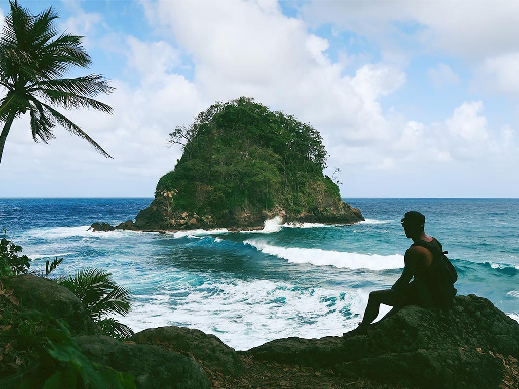 Man sitting on a rock beside the sea in Capurgana.