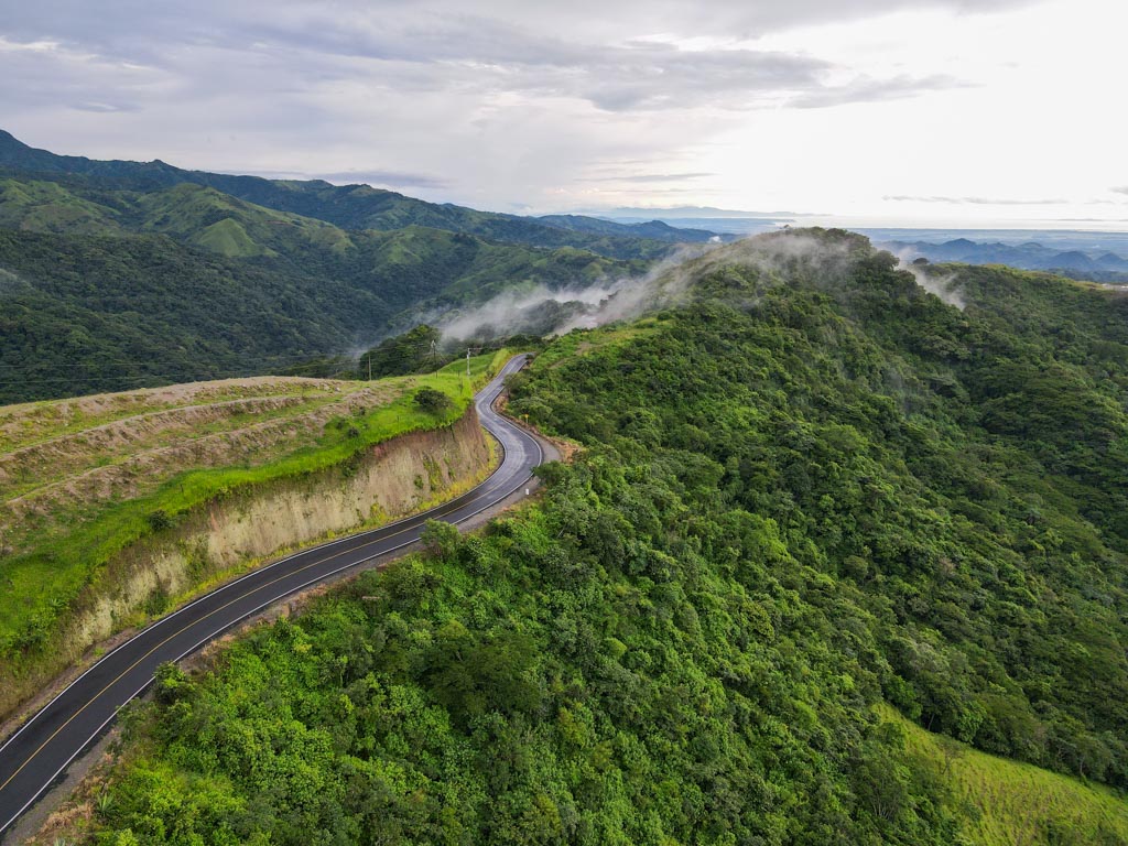 Aerial Shot Route 606 - The Road to Monteverde. Green Mountains and Cloud hovering over them.
