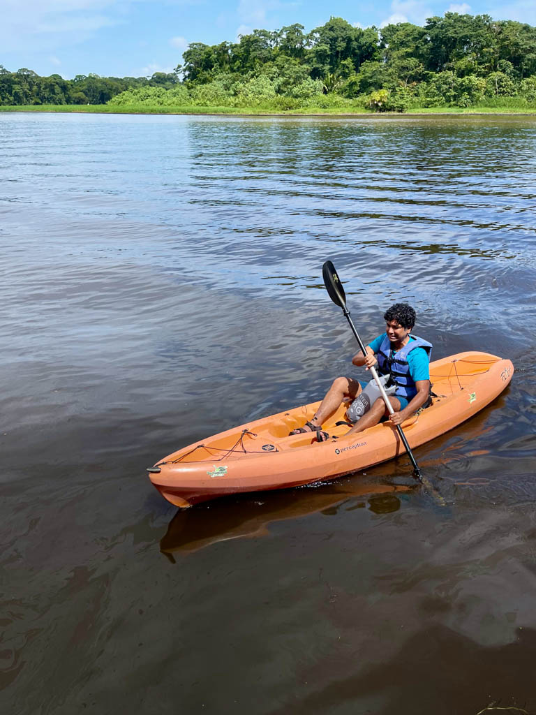 Man on an orange kayak in Tortuguero, Costa Rica.