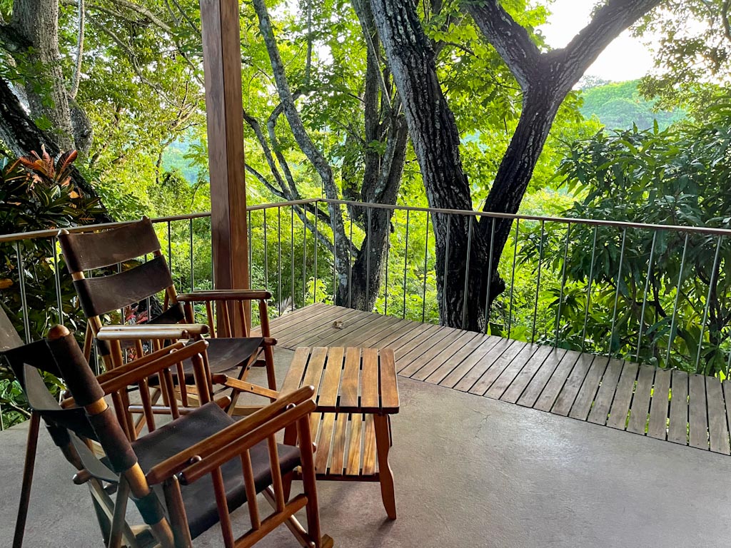 The terrace of our bungalow at Luna Azul. Wooden chairs and table, on a wooden deck with rainforest view creates for a serene atmosphere.