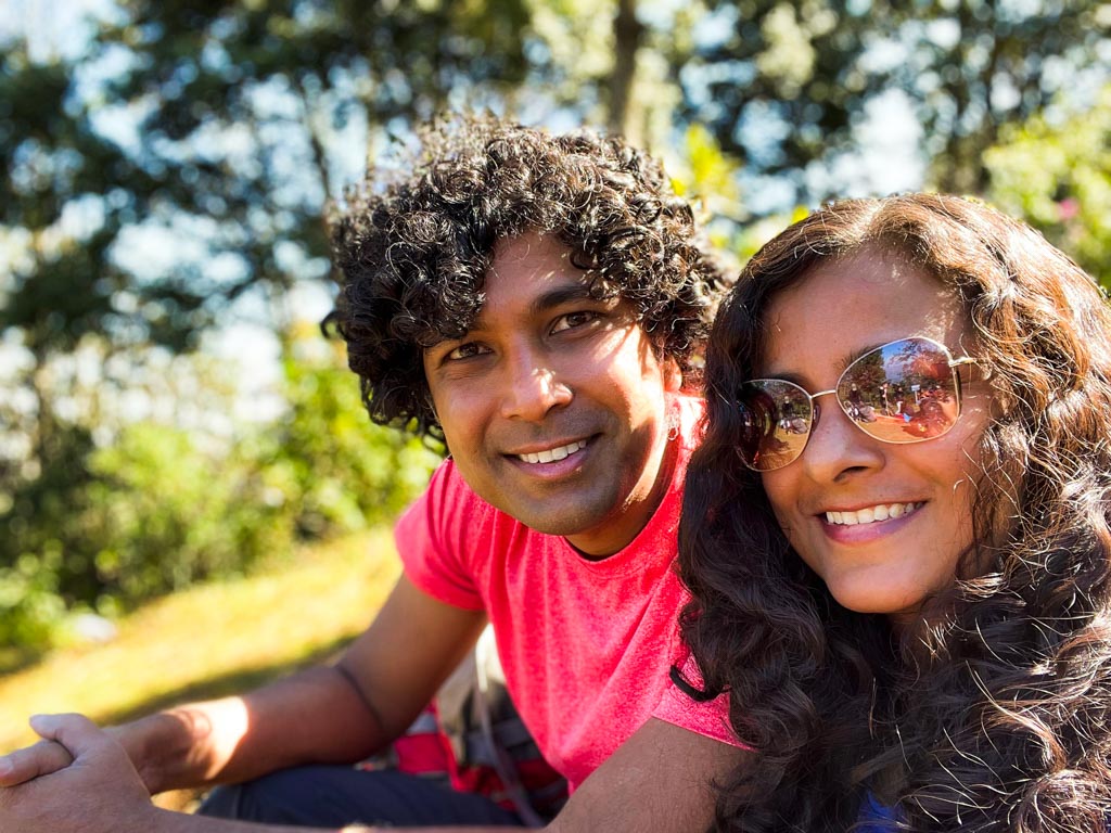 Selfie of a couple sitting on a ground, on the Acatenango hiking trail.