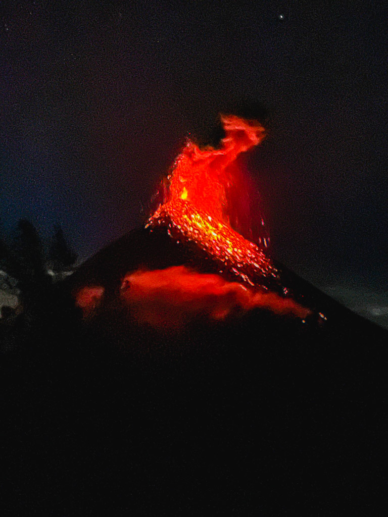 Erupting Fuego volcano at night, as seen from the base camp of Acatenango Volcano hike.