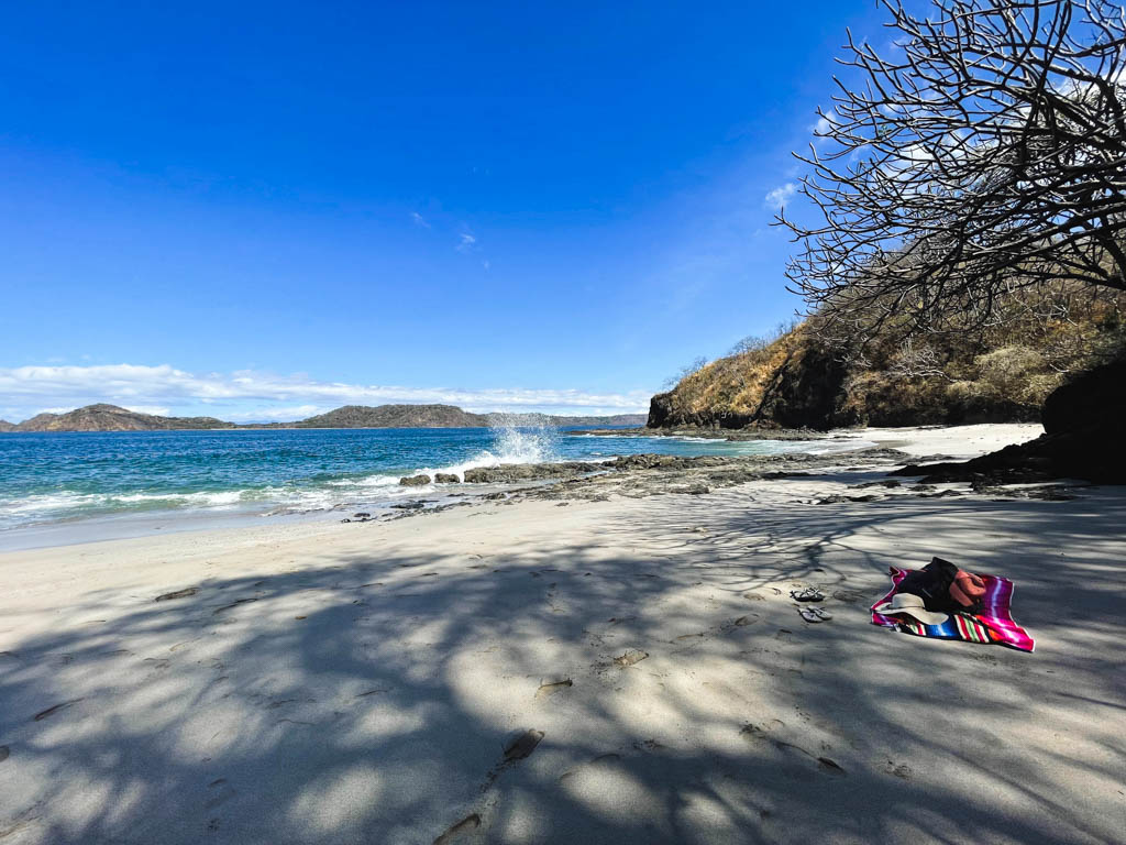 Beach towel, flip-flops, hat and cap on the beautiful beach - Playa Bonita, near Playas del Coco.