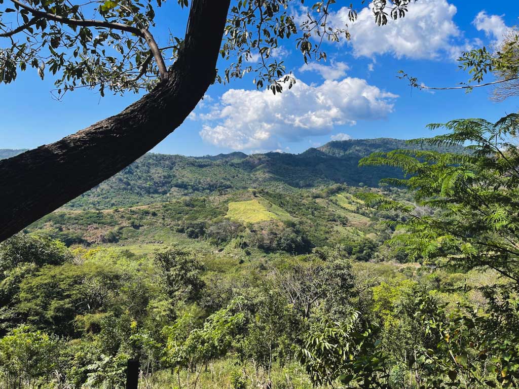 Beautiful vistas of green mountains and valleys, as seen from the Tamanique waterfalls hike trail in El Salvador.