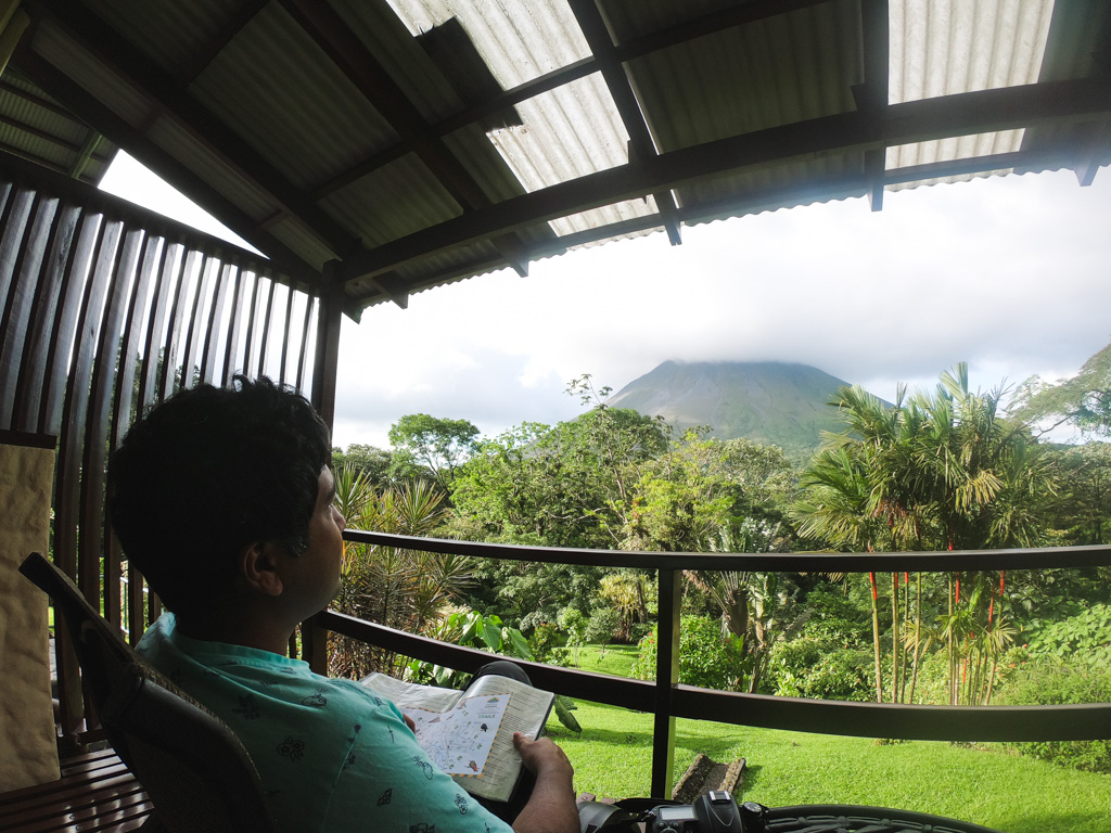 Man enjoying the view of Arenal Volcano from our balcony at Arenal Observatory Lodge.