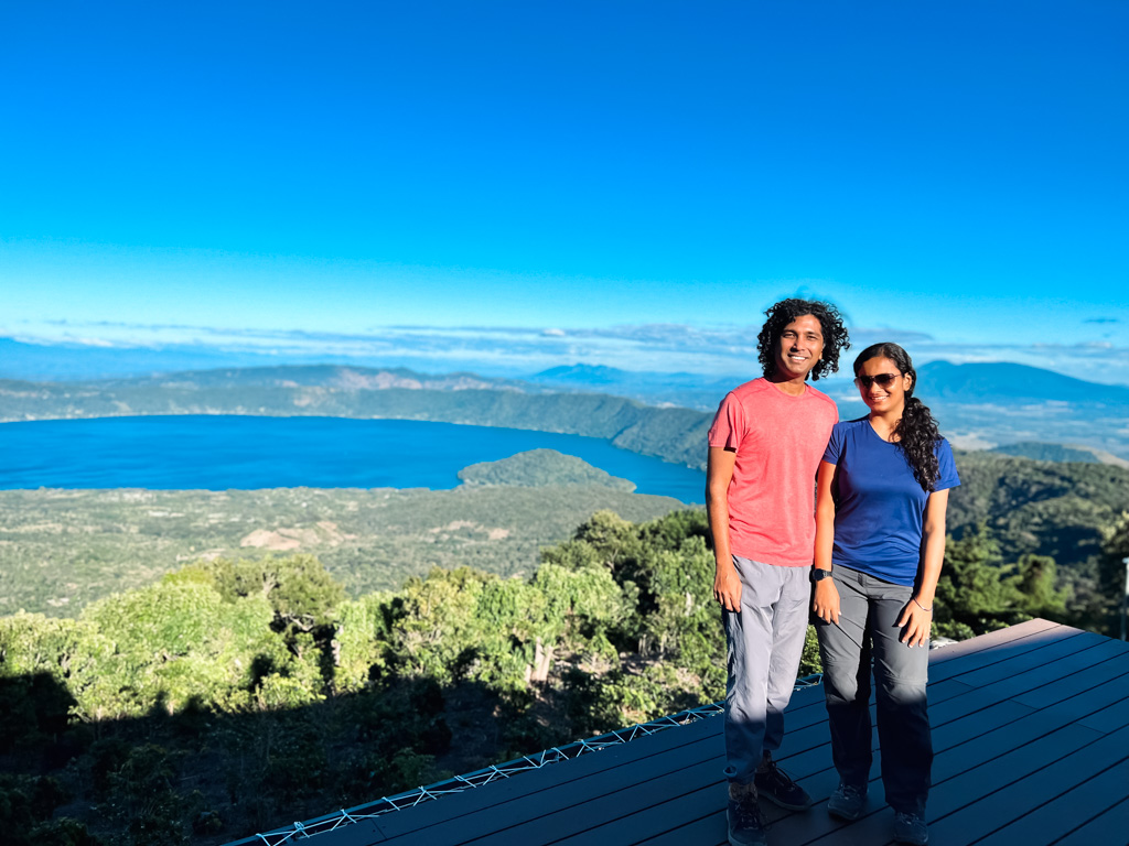 A couple posing for a photo at the Crater Coffee Shop and Bistro, with the Coatepeque Lake in the backdrop.
