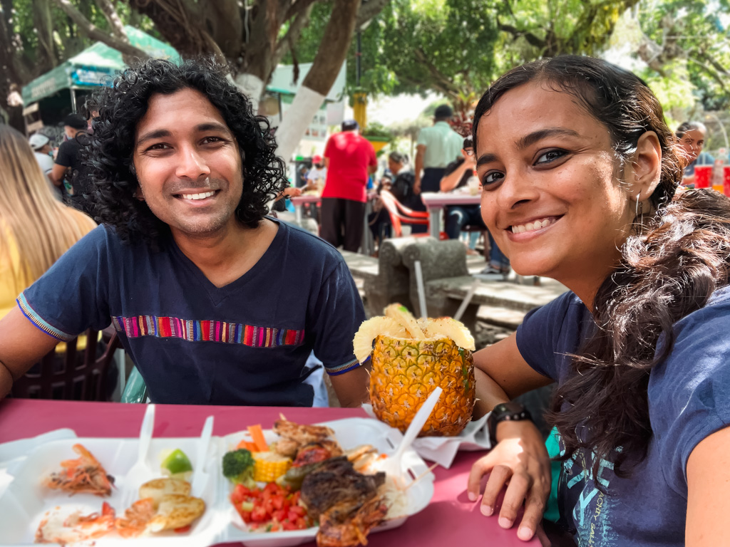 A couple enjoying their food and drinks at the Juayua Food Festival in El Salvador.