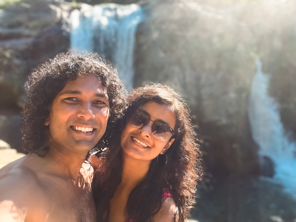 A selfie of a couple with the waterfalls in the background.