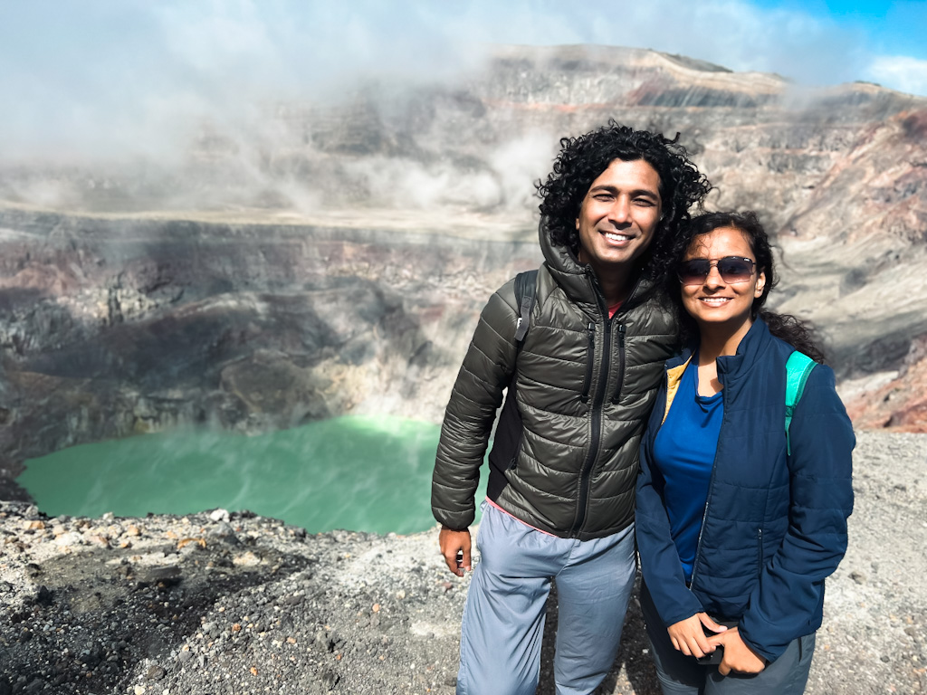 A couple posing next to the crater lake at Santa Ana volcano summit.