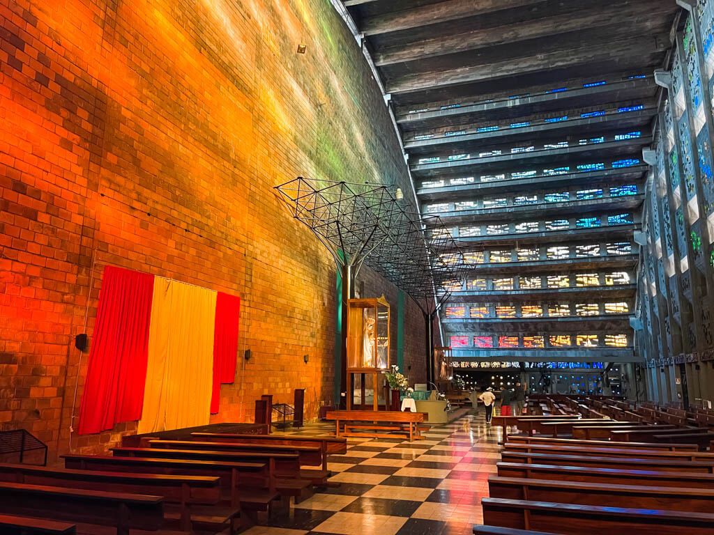Beautiful interior of El Rosario church in San Salvador, characterized by tinted glass and arched walls.
