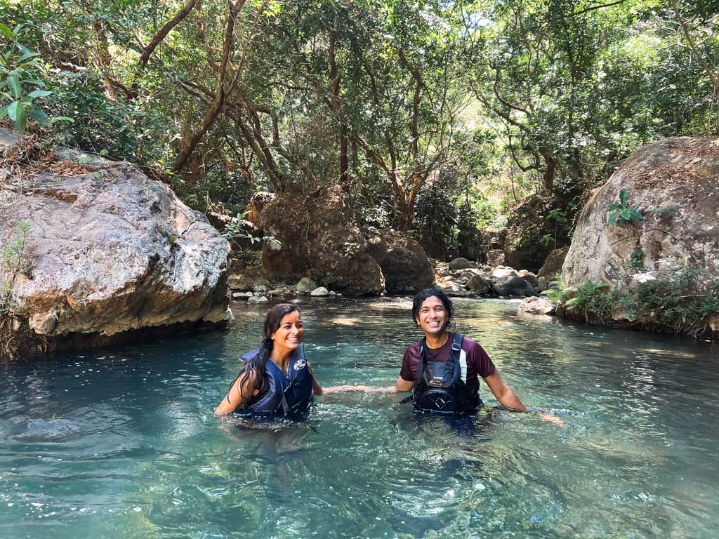 Couple enjoying a swim in Rio Blanco, during Catarata La Leona waterfall hike adventure.