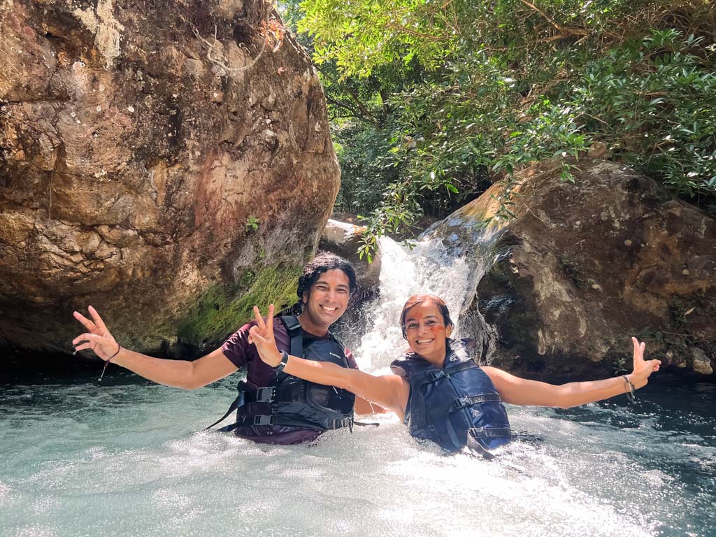 A couple, enjoying the fresh river water, just after the nature slide down during the waterfall hike.